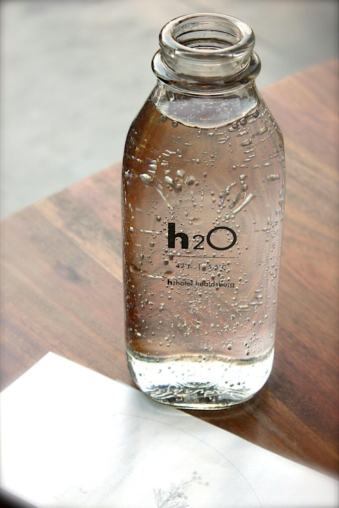 Close-up of a sparkling water bottle on a wooden table, refreshing and hydrating.
