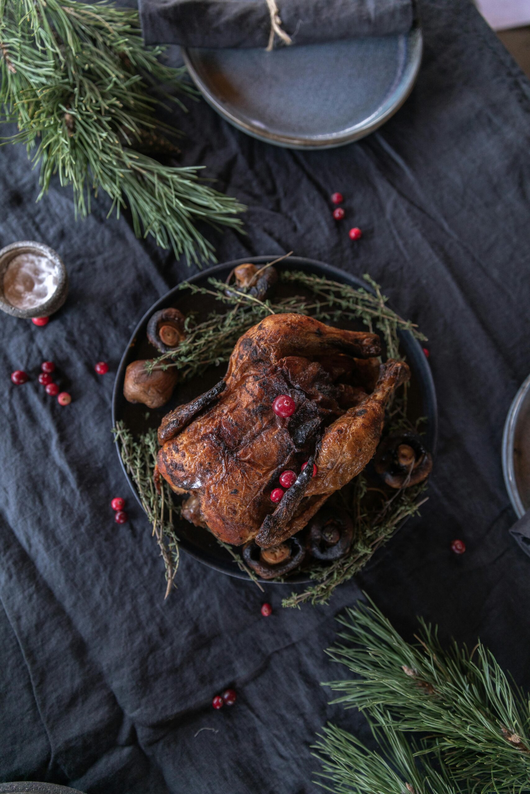 Delicious roasted turkey with herbs and berries on a festive table setting.