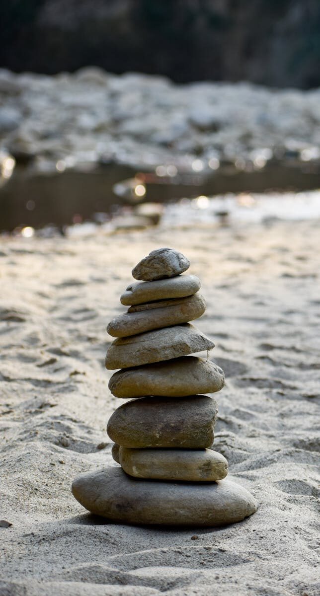 A serene stack of stones on sandy beach, exemplifying balance and harmony.
