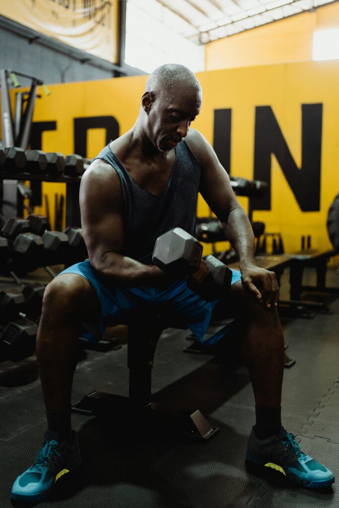 Focused athlete lifting dumbbells in a gym, showcasing strength and fitness.