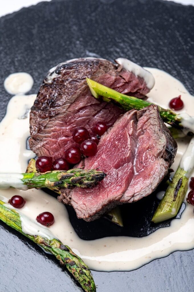 A piece of steak with asparagus on a plate